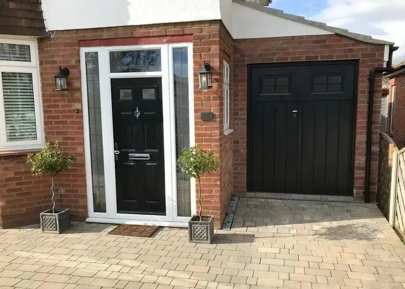 Garage door repair Pasadena—black up-and-over garage door with matching composite front door on brick semi-detached home